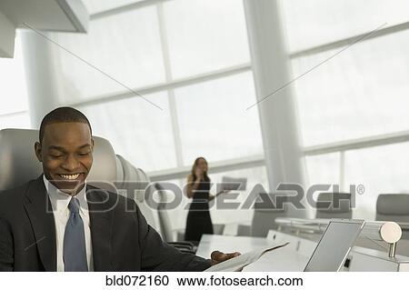 African businessman reading newspaper in conference room View Large Photo Image Stock Image - African businessman reading newspaper in conference room. Fotosearch