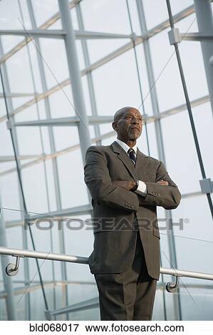 Stock Photo - African businessman standing with arms crossed. Fotosearch