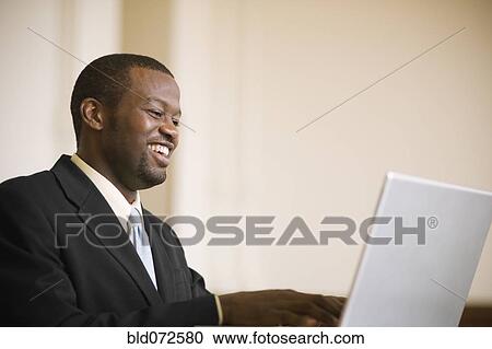 African businessman typing on laptop View Large Photo Image Stock Image - African businessman typing on laptop. Fotosearch