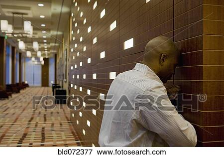 Stock Photo - African businessman with head against wall. Fotosearch