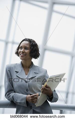 African businesswoman holding paperwork View Large Photo Image Picture - African businesswoman holding paperwork. Fotosearch