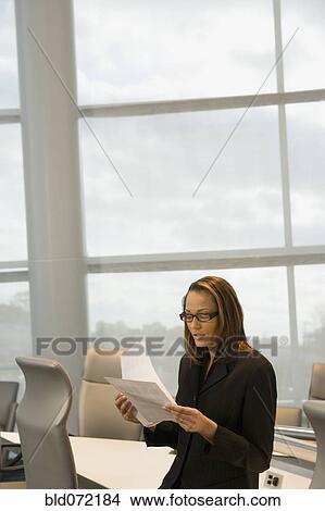Picture - African businesswoman reviewing paperwork. Fotosearch
