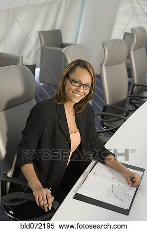 African businesswoman sitting in conference room with binder View Large Photo Image Stock Photography - African businesswoman sitting in conference room with binder. Fotosearch
