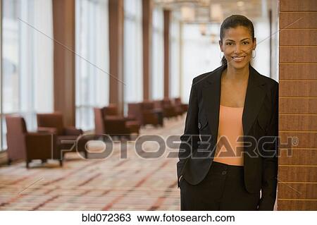 Stock Image - African businesswoman standing in lobby. Fotosearch