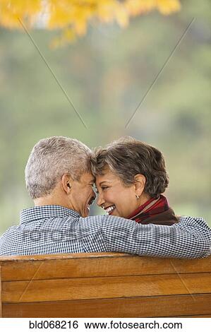 African couple hugging on park bench View Large Photo Image Stock Photograph - African couple hugging on park bench. Fotosearch