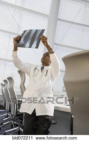 Stock Image - African doctor reviewing x-ray. Fotosearch