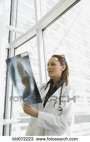 Stock Image - African doctor reviewing x-ray. Fotosearch