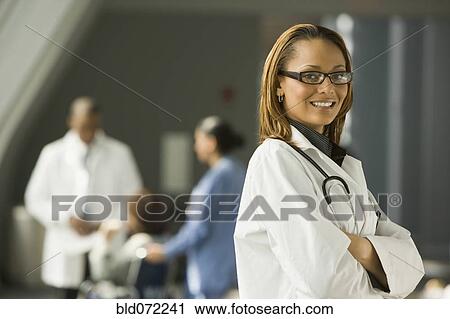 Stock Image - African doctor with arms crossed smiling. Fotosearch