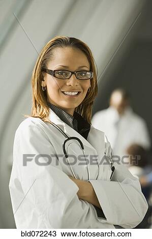 Stock Image - African doctor with arms crossed smiling. Fotosearch