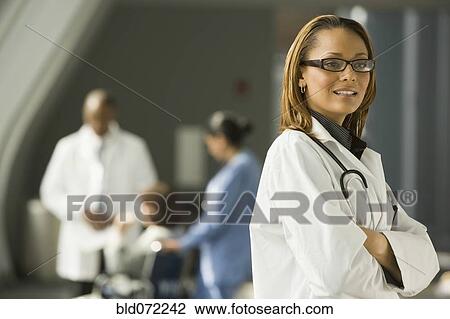 Stock Image - African doctor with arms crossed looking pensive. Fotosearch