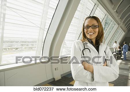 African doctor with arms crossed smiling in corridor View Large Photo Image Stock Photo - African doctor with arms crossed smiling in corridor. Fotosearch