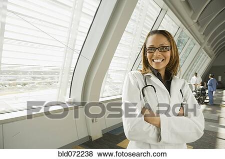 African doctor with arms crossed smiling in corridor View Large Photo Image Stock Photo - African doctor with arms crossed smiling in corridor. Fotosearch