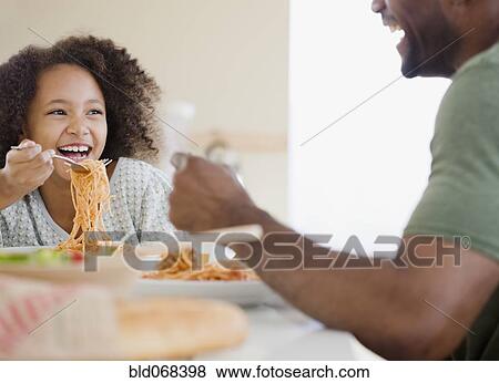 African father and daughter eating pasta View Large Photo Image Stock Photo - African father and daughter eating pasta. Fotosearch