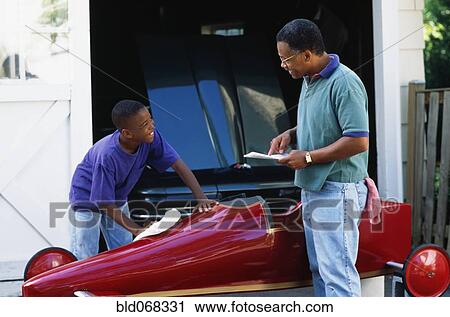 Stock Image - African father and son with go-cart. Fotosearch