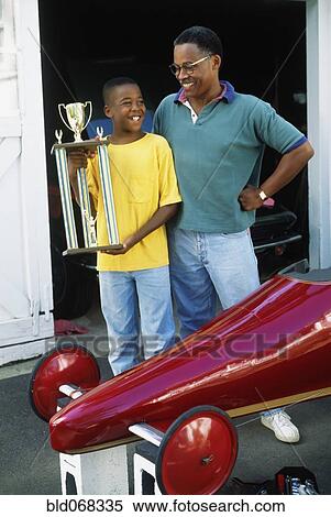Stock Photography - African father and son with go-cart trophy. Fotosearch