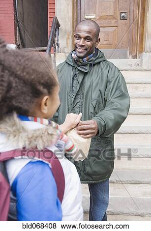 Stock Photo - African father giving lunch bag to daughter. Fotosearch