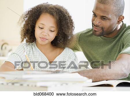Stock Image - African father helping daughter with homework. Fotosearch