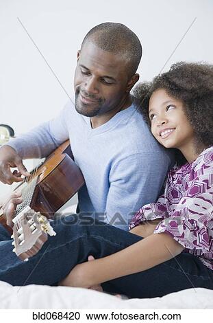 African father playing guitar for daughter View Large Photo Image Stock Image - African father playing guitar for daughter. Fotosearch