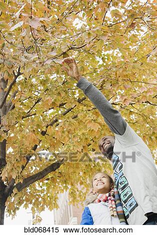 Stock Photography - African father showing tree to daughter. Fotosearch
