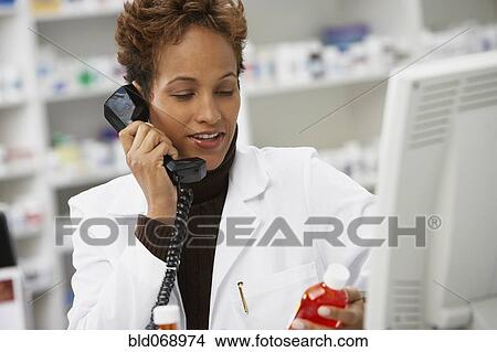 African female pharmacist talking on telephone View Large Photo Image Picture - African female pharmacist talking on telephone. Fotosearch