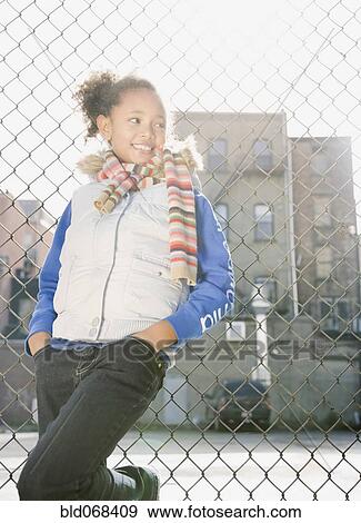 African girl leaning against fence View Large Photo Image Stock Photo - African girl leaning against fence. Fotosearch