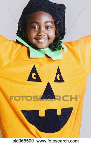 Stock Photo - African girl wearing pumpkin costume. Fotosearch