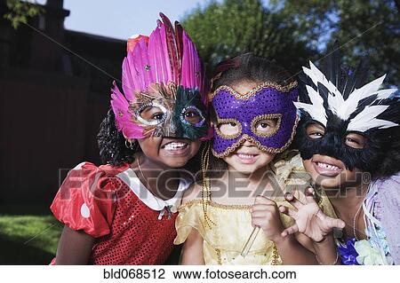 Stock Image - African girls wearing masks. Fotosearch