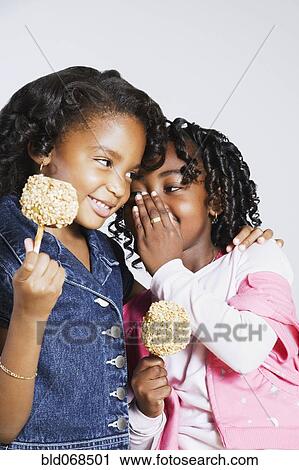 Stock Image - African girls whispering secrets. Fotosearch