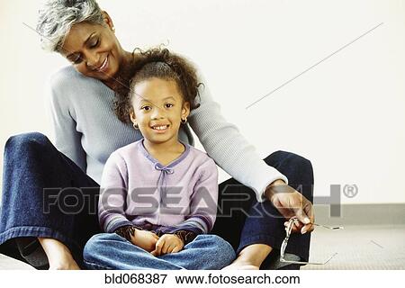 African grandmother and granddaughter sitting on floor View Large Photo Image Stock Photo - African grandmother and granddaughter sitting on floor. Fotosearch