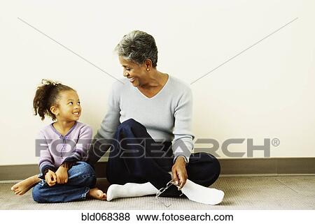African grandmother and granddaughter sitting on floor View Large Photo Image Stock Photo - African grandmother and granddaughter sitting on floor. Fotosearch