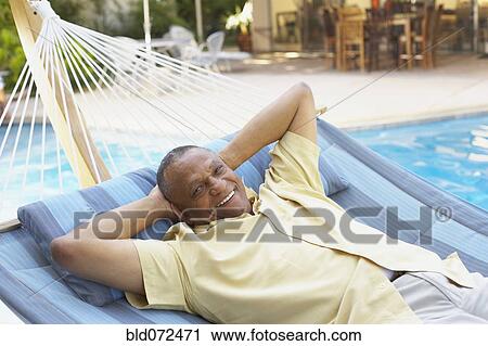 African man laying in hammock at poolside View Large Photo Image Stock Image - African man laying in hammock at poolside. Fotosearch