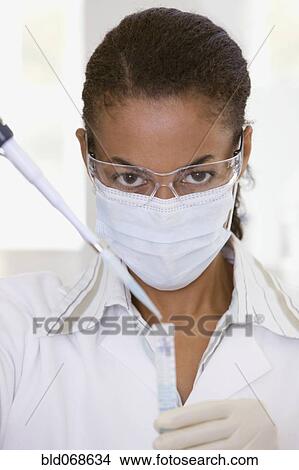 Picture - African scientist performing analysis in laboratory. Fotosearch