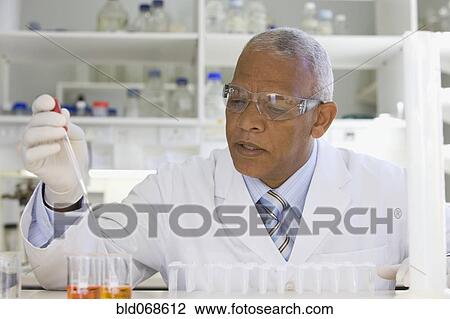 Stock Image - African scientist performing analysis in laboratory. Fotosearch
