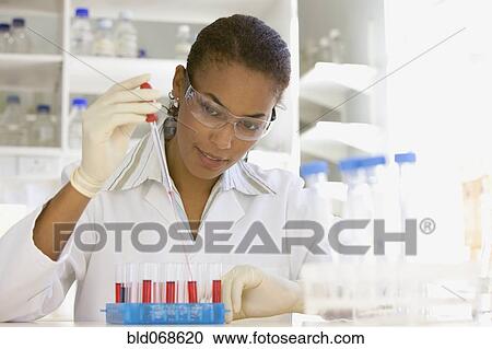Stock Image - African scientist performing analysis in laboratory. Fotosearch