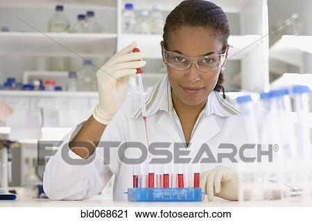 Stock Image - African scientist performing analysis in laboratory. Fotosearch