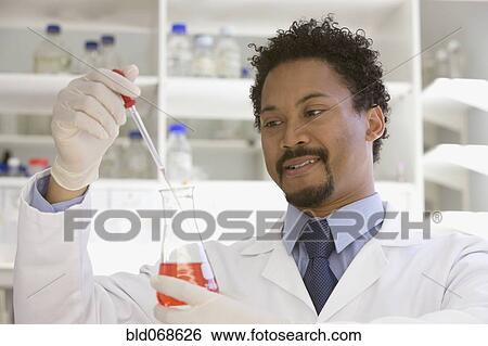 Stock Photograph - African scientist performing analysis in laboratory. Fotosearch