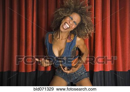 Stock Photo - African woman dancing in front of curtain. Fotosearch
