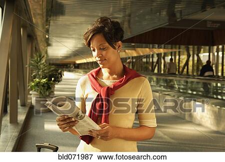 Stock Photo - African woman reading newspaper. Fotosearch