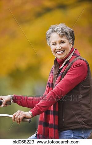 Stock Image - African woman sitting on bicycle. Fotosearch