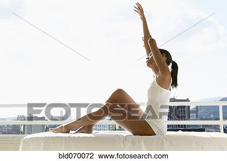 Stock Image - African woman stretching on balcony. Fotosearch