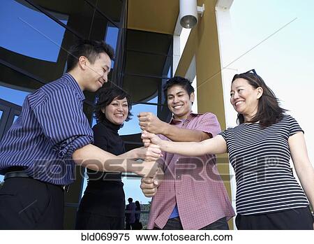 Stock Photography - Asian businesspeople being silly outdoors. Fotosearch