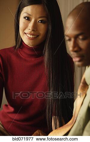 Asian businesswoman next to African businessman View Large Photo Image Stock Photo - Asian businesswoman next to African businessman. Fotosearch