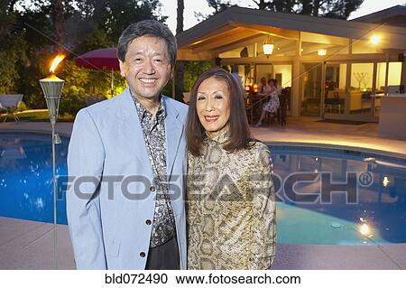 Stock Image - Asian couple enjoying pool party. Fotosearch