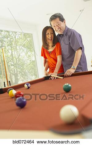Picture - Asian couple playing pool. Fotosearch