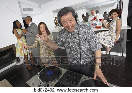 Stock Image - Asian DJ performing at party. Fotosearch