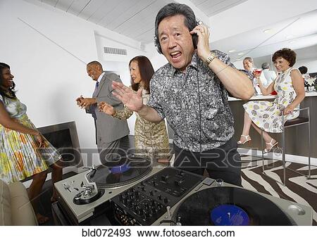 Stock Image - Asian DJ performing at party. Fotosearch