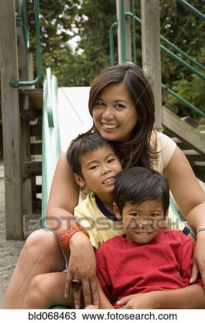 Asian family sitting together on slide View Large Photo Image Stock Image - Asian family sitting together on slide. Fotosearch