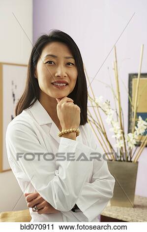 Stock Image - Asian female doctor in office. Fotosearch
