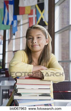 Asian girl leaning on stack of books View Large Photo Image Stock Image - Asian girl leaning on stack of books. Fotosearch