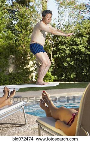 Asian man diving into swimming pool View Large Photo Image Picture - Asian man diving into swimming pool. Fotosearch